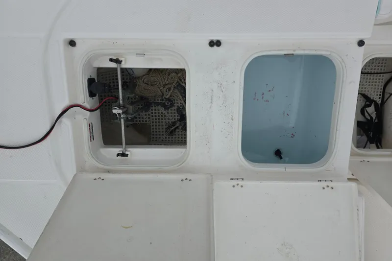 Slide: The Image of 2021 Robalo 246 Cayman storage compartments with wiring and rope. - 8