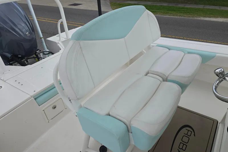Slide: The Image of 2021 Robalo 246 Cayman boat interior with cushioned seating and steering wheel. - 9