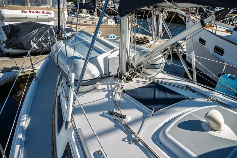 Slide: The Image of 2003 Hunter 356 sailboat deck with rigging and lifeboat in marina. - 10