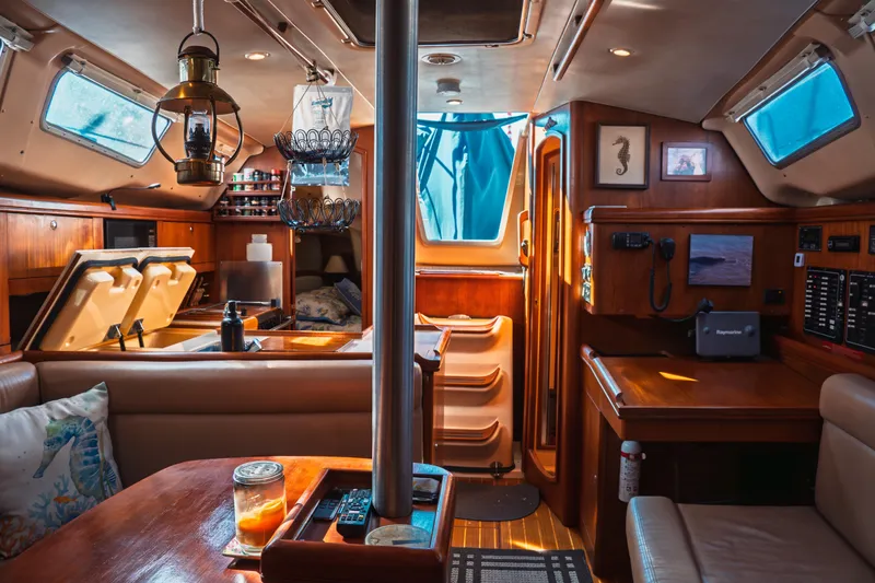 Slide: The Image of Interior of a 2003 Hunter 356 sailboat, featuring cozy wooden furnishings and nautical decor. - 13
