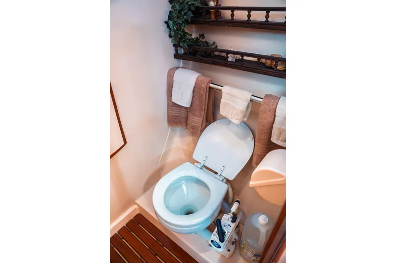 Slide: The Image of Compact bathroom in 2003 Hunter 356 yacht with toilet, towels, and wooden floor mat. - 22
