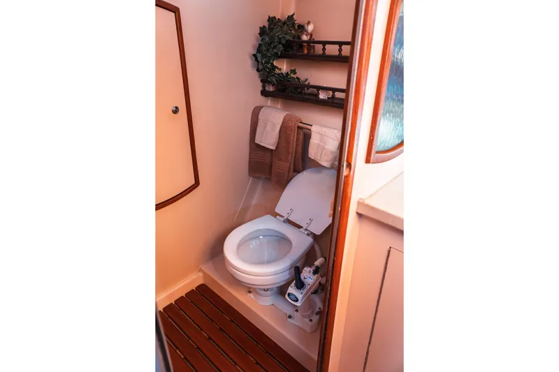 Slide: The Image of Compact bathroom in 2003 Hunter 356 yacht with toilet, wooden floor, and shelves. - 24