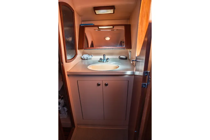 Slide: The Image of Compact bathroom in a 2003 Hunter 356 yacht with sink, mirror, and storage cabinet. - 25
