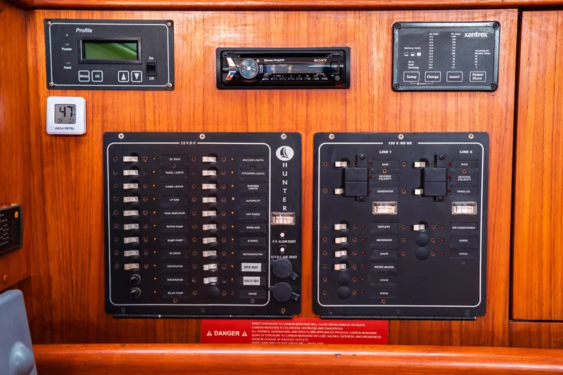 Slide: The Image of Control panel of a 2003 Hunter 356 sailboat with various switches and displays. - 26