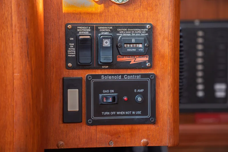 Slide: The Image of Control panel of a 2003 Hunter 356 boat with generator and solenoid switches. - 28