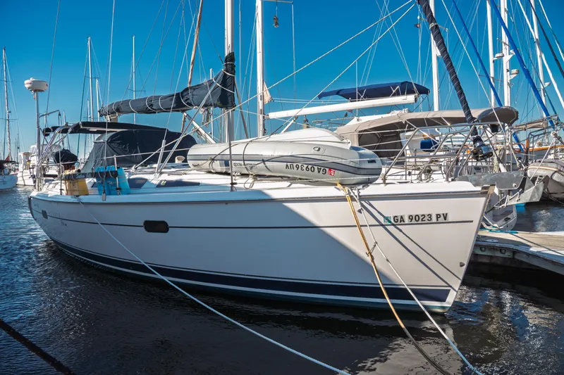 Slide: The Image of 2003 Hunter 356 sailboat docked in marina, featuring sleek design and inflatable dinghy. - 3