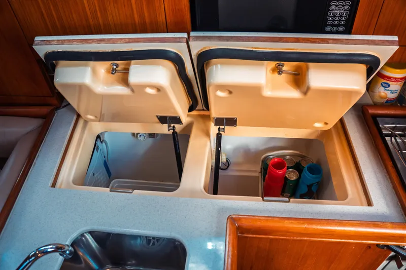 Slide: The Image of 2003 Hunter 356 yacht kitchen with open storage compartments and sink. - 31
