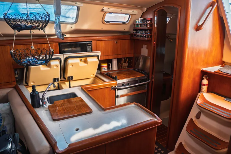 Slide: The Image of 2003 Hunter 356 yacht interior kitchen with wood cabinetry and modern appliances. - 34