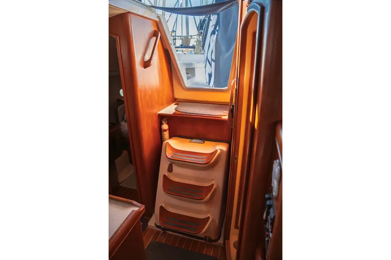 Slide: The Image of Interior of 2003 Hunter 356 sailboat with wooden cabinetry and storage compartments. - 35