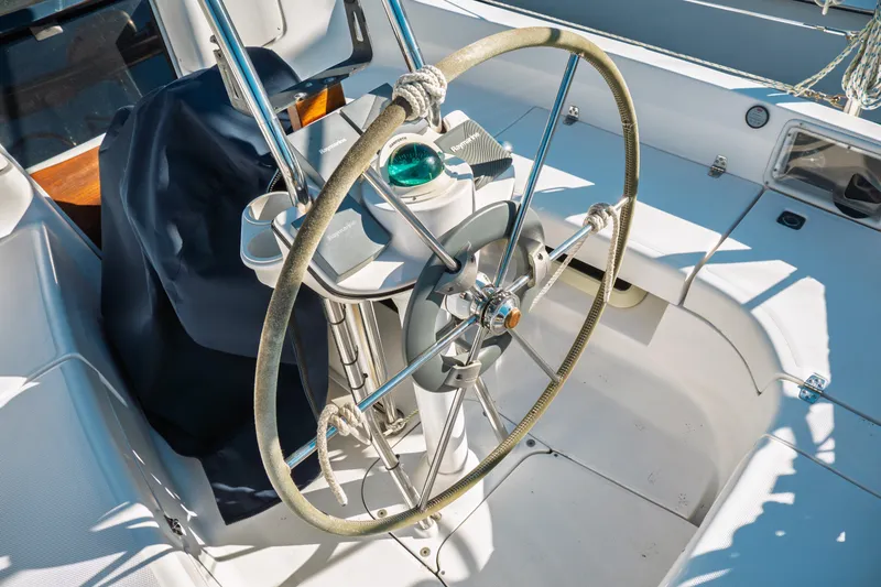 Slide: The Image of Steering wheel of a 2003 Hunter 356 sailboat, featuring a compass and navigation equipment. - 6