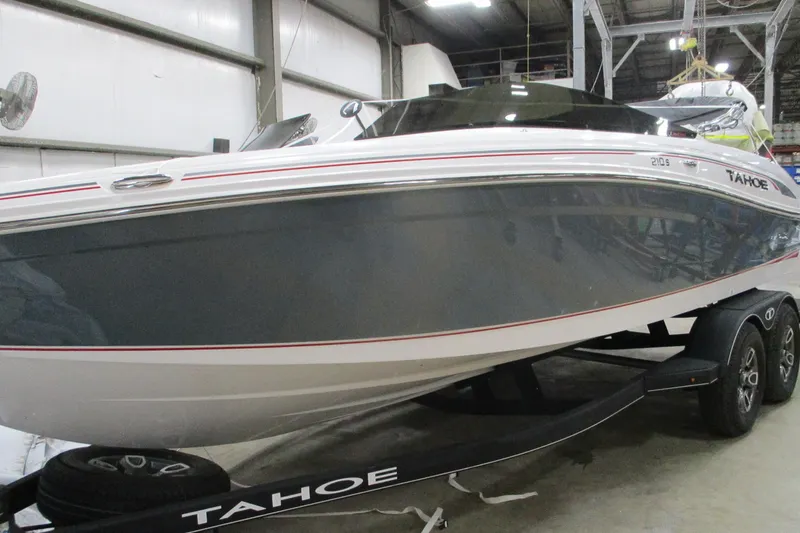 The Image of 2024 Tahoe 210 S Limited boat on trailer in indoor storage facility. - 0