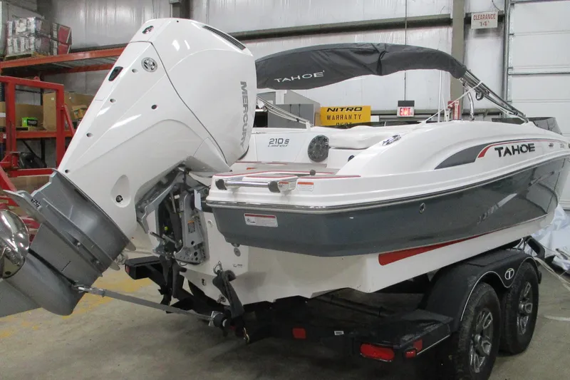 Slide: The Image of 2024 Tahoe 210 S Limited boat in a garage, featuring a powerful Mercury outboard engine. - 3