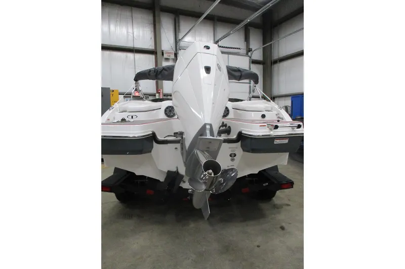 Slide: The Image of 2024 Tahoe 210 S Limited boat, rear view in a warehouse setting. - 4