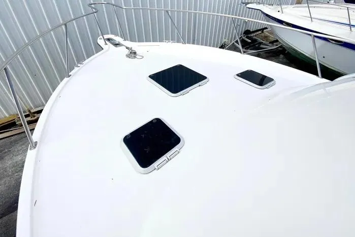 Slide: The Image of 2001 Pursuit 3000 Offshore boat deck with hatches, docked near other vessels. - 11