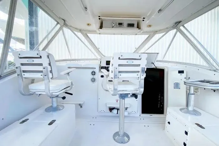 Slide: The Image of 2001 Pursuit 3000 Offshore boat interior with helm and seating area. - 12