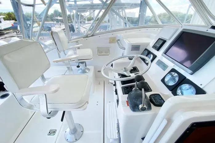 Slide: The Image of 2001 Pursuit 3000 Offshore boat cockpit with steering wheel, controls, and white seating. - 15