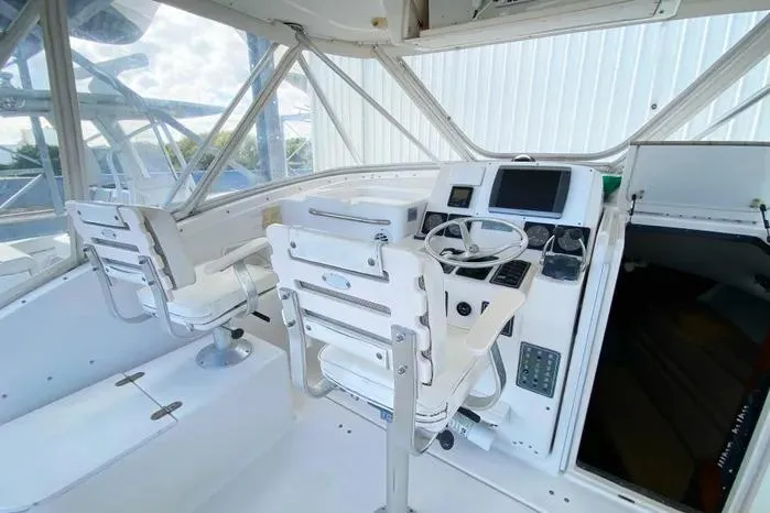 Slide: The Image of 2001 Pursuit 3000 Offshore boat cockpit with steering wheel and seating. - 16