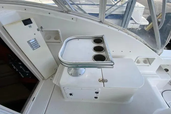 Slide: The Image of 2001 Pursuit 3000 Offshore boat interior with cup holders and control panel. - 17