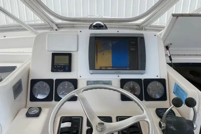 Slide: The Image of 2001 Pursuit 3000 Offshore boat dashboard with navigation and control instruments. - 19