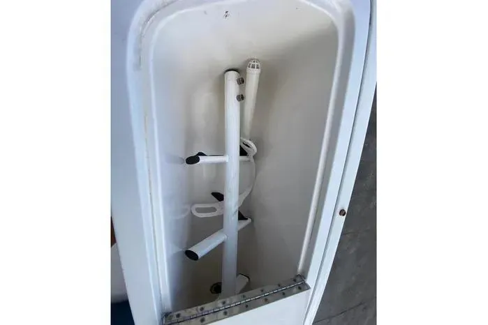 Slide: The Image of Storage compartment on a 2001 Pursuit 3000 Offshore boat, featuring rod holders. - 21