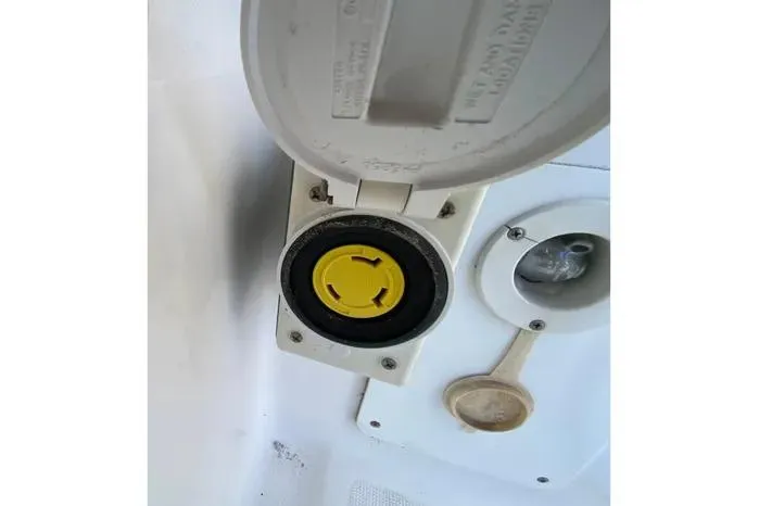 Slide: The Image of 2001 Pursuit 3000 Offshore boat power outlet with yellow connector and cover. - 23