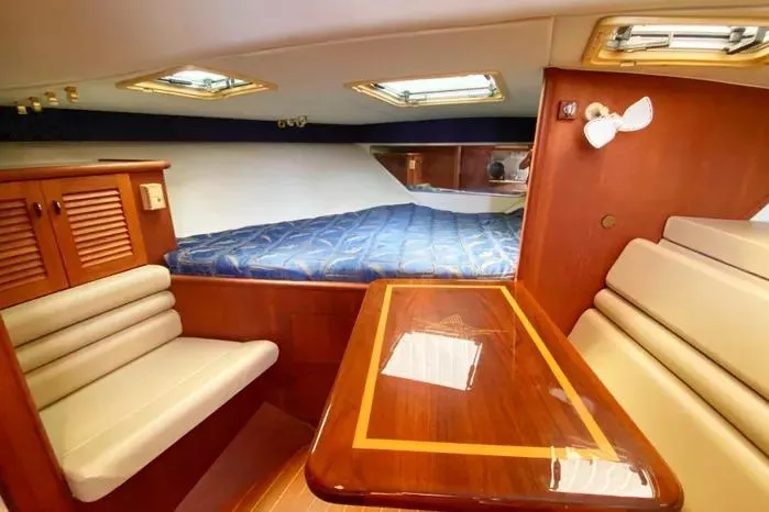 Slide: The Image of Interior of 2001 Pursuit 3000 Offshore boat with cozy seating and wooden table. - 32