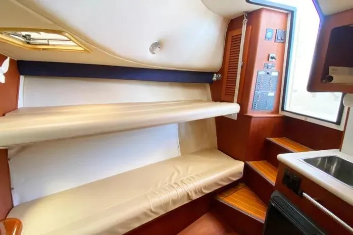 Slide: The Image of Interior of 2001 Pursuit 3000 Offshore boat with bunk beds and wooden steps. - 33