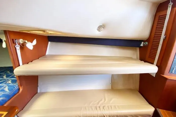 Slide: The Image of Interior cabin of 2001 Pursuit 3000 Offshore boat with beige seating and wooden accents. - 34