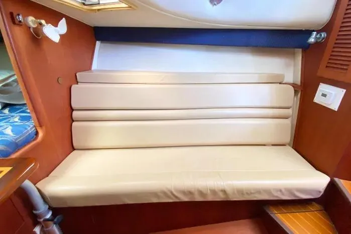 Slide: The Image of 2001 Pursuit 3000 Offshore cabin interior with beige seating and wooden accents. - 35