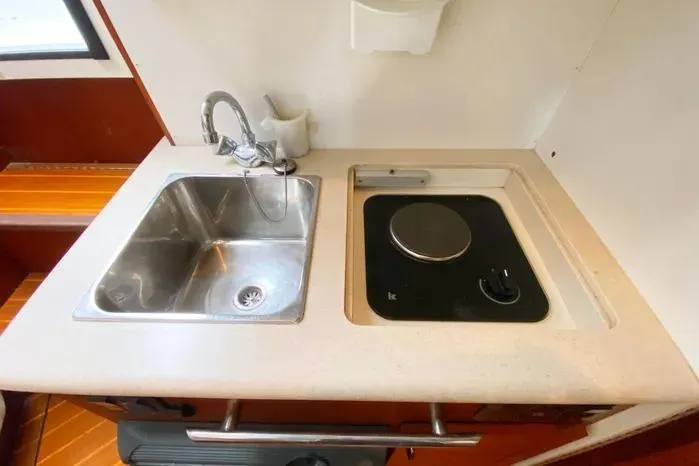 Slide: The Image of 2001 Pursuit 3000 Offshore boat kitchen with sink and stove. - 38