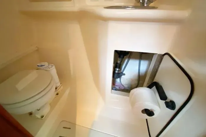 Slide: The Image of 2001 Pursuit 3000 Offshore boat bathroom with toilet, sink, and storage compartment. - 41