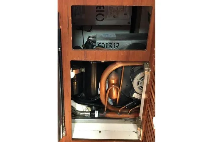 Slide: The Image of 2001 Pursuit 3000 Offshore boat engine compartment with visible copper pipes and components. - 43