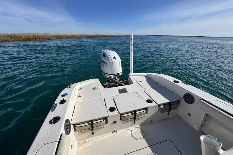 Slide: The Image of 2022 Carolina Skiff 24 Ultra Elite boat on open water, featuring Suzuki outboard motor. - 20
