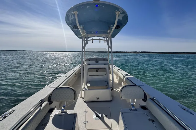 Slide: The Image of 2022 Carolina Skiff 24 Ultra Elite boat on calm water under clear sky. - 21