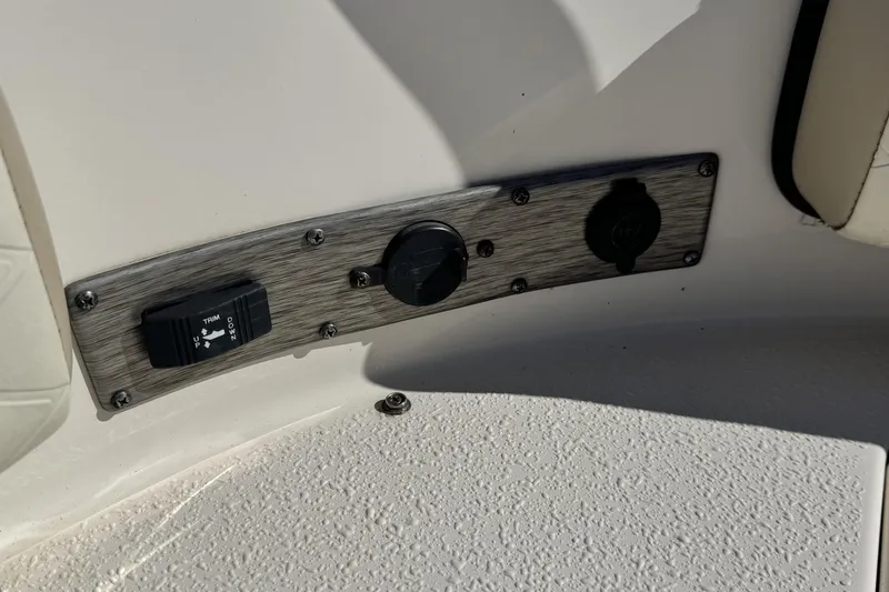 Slide: The Image of Control panel on 2022 Carolina Skiff 24 Ultra Elite boat, featuring trim switch and outlets. - 36