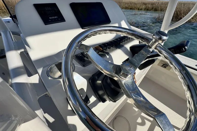 Slide: The Image of 2022 Carolina Skiff 24 Ultra Elite boat helm with steering wheel and controls. - 6