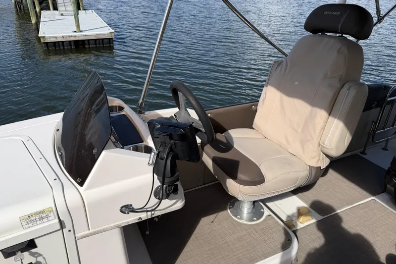 Slide: The Image of 2017 Bayliner Element XR7 boat helm with beige captain's chair and steering wheel. - 10