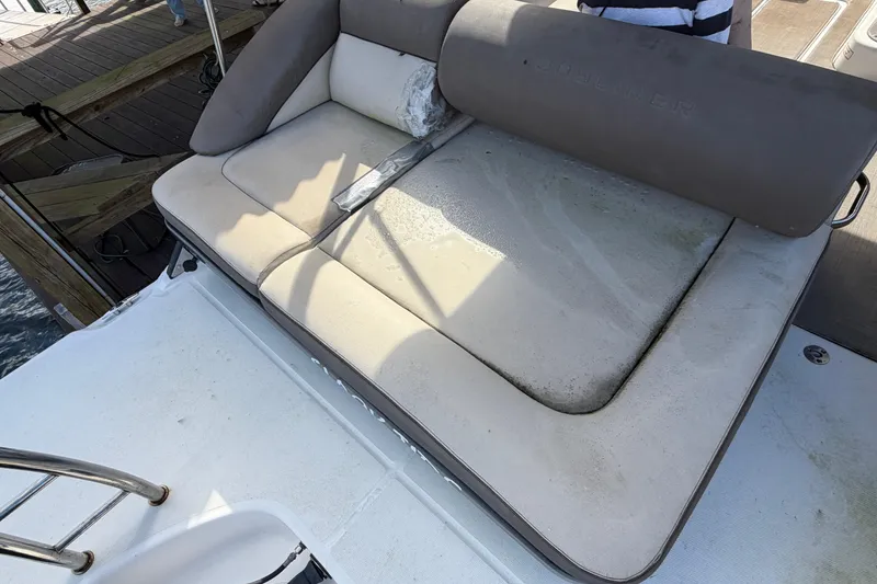 Slide: The Image of 2017 Bayliner Element XR7 boat with sunlit, cushioned seating area near dock. - 13