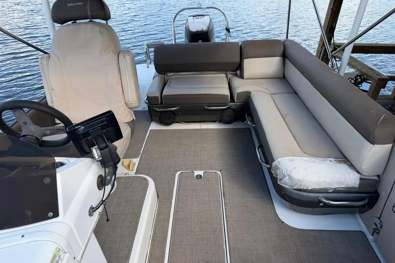 Slide: The Image of 2017 Bayliner Element XR7 boat interior with seating and steering wheel on water. - 14