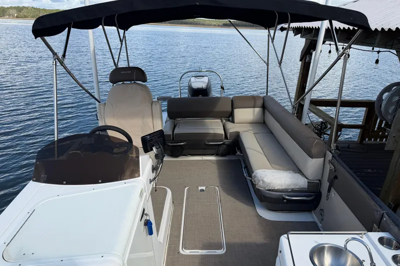 Slide: The Image of 2017 Bayliner Element XR7 boat interior with seating and canopy on calm water. - 15