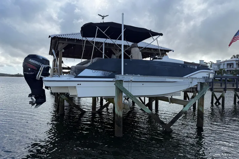Slide: The Image of 2017 Bayliner Element XR7 boat on lift, docked by waterfront property. - 2