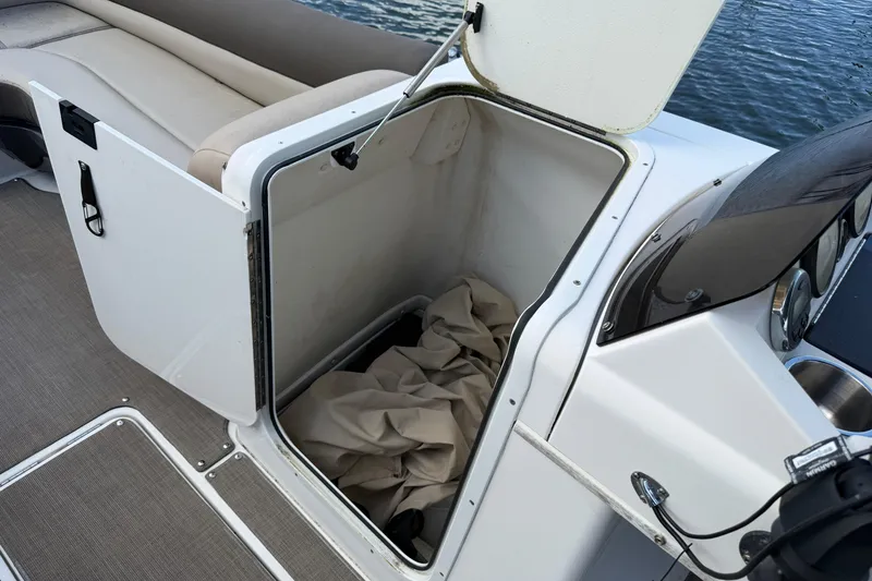 Slide: The Image of 2017 Bayliner Element XR7 boat storage compartment with open hatch and beige cover inside. - 6