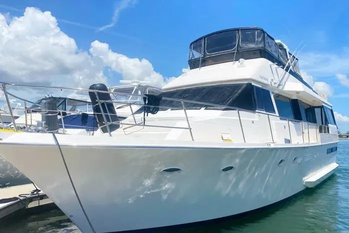Slide: The Image of 1990 Viking Motor Yacht docked under a clear blue sky. - 1