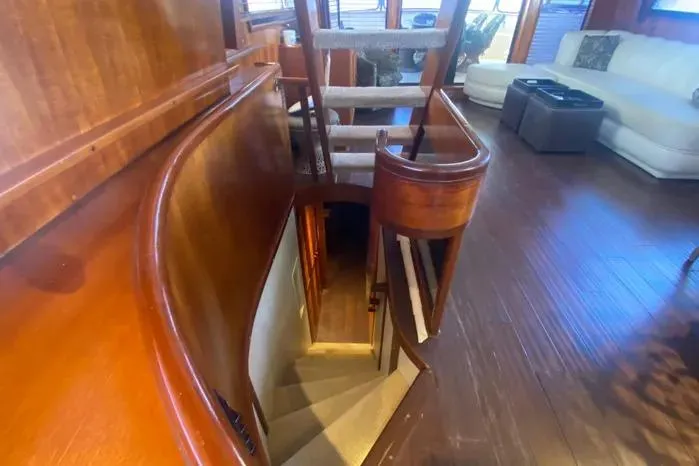 Slide: The Image of Interior of a 1990 Viking Motor Yacht with wooden stairs and elegant seating area. - 15