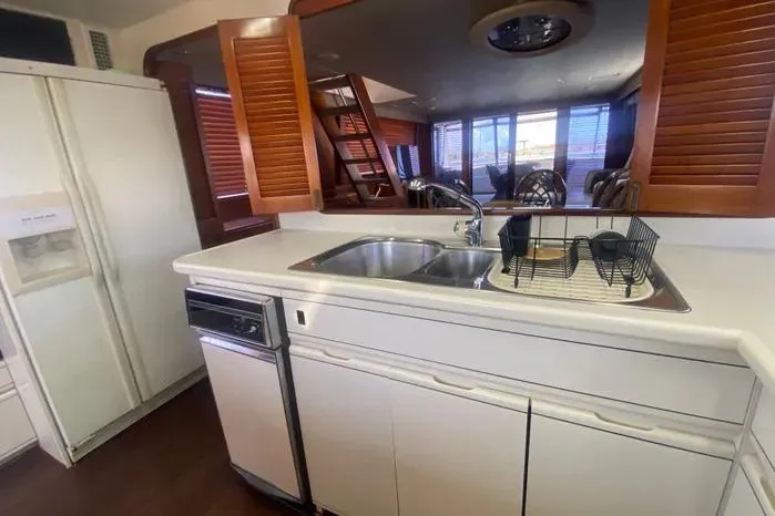 Slide: The Image of 1990 Viking Motor Yacht kitchen with sink, dishwasher, and refrigerator. - 18