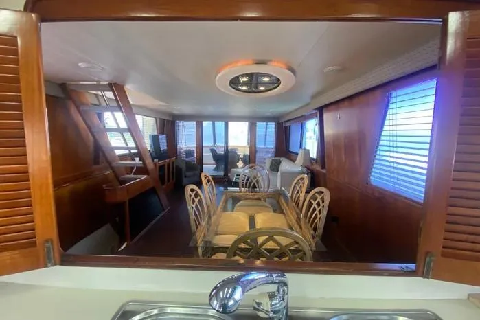 Slide: The Image of Interior of a 1990 Viking Motor Yacht featuring a dining area with wooden accents. - 21