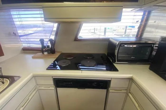 Slide: The Image of 1990 Viking Motor Yacht kitchen with stove, microwave, and countertop accessories. - 25