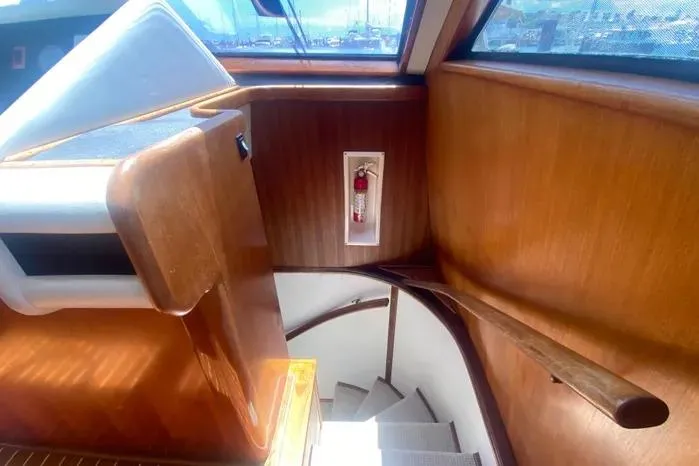Slide: The Image of Interior staircase of a 1990 Viking Motor Yacht with wooden paneling and a fire extinguisher. - 26