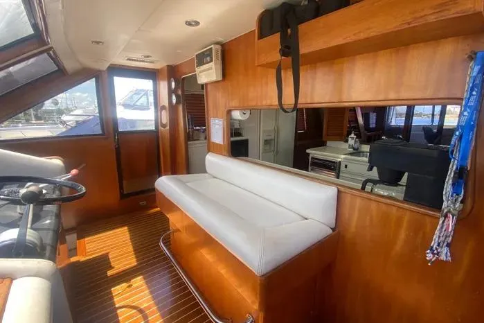 Slide: The Image of 1990 Viking Motor Yacht interior with wooden paneling and white seating. - 28