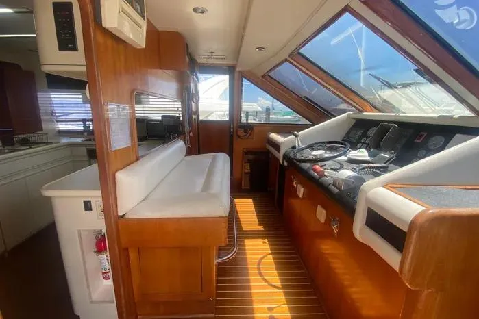 Slide: The Image of Interior of 1990 Viking Motor Yacht with wooden accents and navigation controls. - 30